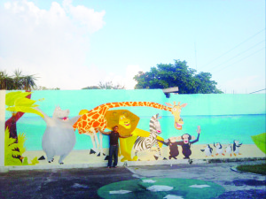 Aquí, posando con una de sus obras de arte. Un mural realizado en una barda de un kínder de su natal Veracruz.