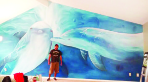 Con la pintura finalizada de los delfines, una de sus obras que guarda grandes recuerdos. (Foto Cortesia de Jorge)
